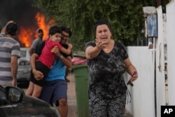 Cetățeni israelieni se evacuează după ce o rachetă lansată din Fâșia Gaza, în Ashkelon, sudul Israelului, pe 8 octombrie 2023.
