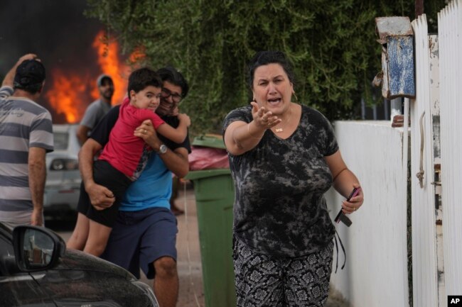 Cittadini israeliani evacuano dopo che un razzo è stato lanciato dalla Striscia di Gaza ad Ashkelon, nel sud di Israele, l'8 ottobre 2023.
