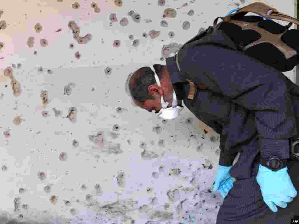 Pakistan -- An investigator collects evidence at the suicide blast site at Islamic International University in Islamabad, 20Oct2009 - PAKISTAN, Islamabad : Pakistani investigators collect evidence at the suicide blast site at Islamic International University in Islamabad on October 20, 2009. A double suicide bombing at a university campus in Pakistan's capital killed up to seven people, including the two bombers, an administration official said.