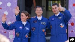 NASA astronaut Loral O'Hara (left) and cosmonauts Oleg Kononenko and Nikolai Chub wave as they prepare for the launch of a Russian spacecraft from the Baikonur Cosmodrome in Kazakhstan on September 15. 