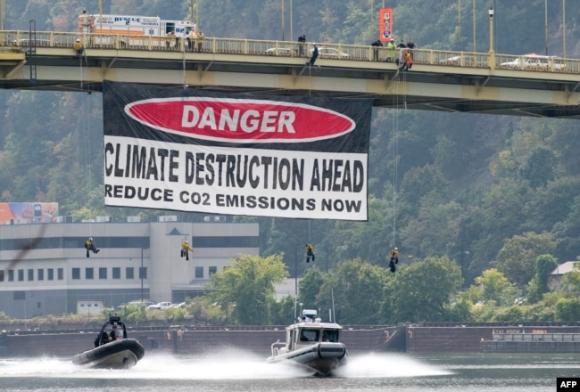 Greenpeace-aktivisták molinója – „Vigyázat, klímapusztítás következik, csökkentsük a szén-dioxid-kibocsátást most!” – a pennsylvaniai Ohio folyónál, a G20-ak csúcstalálkozójának helyszínén, 2009. szeptember 23-án