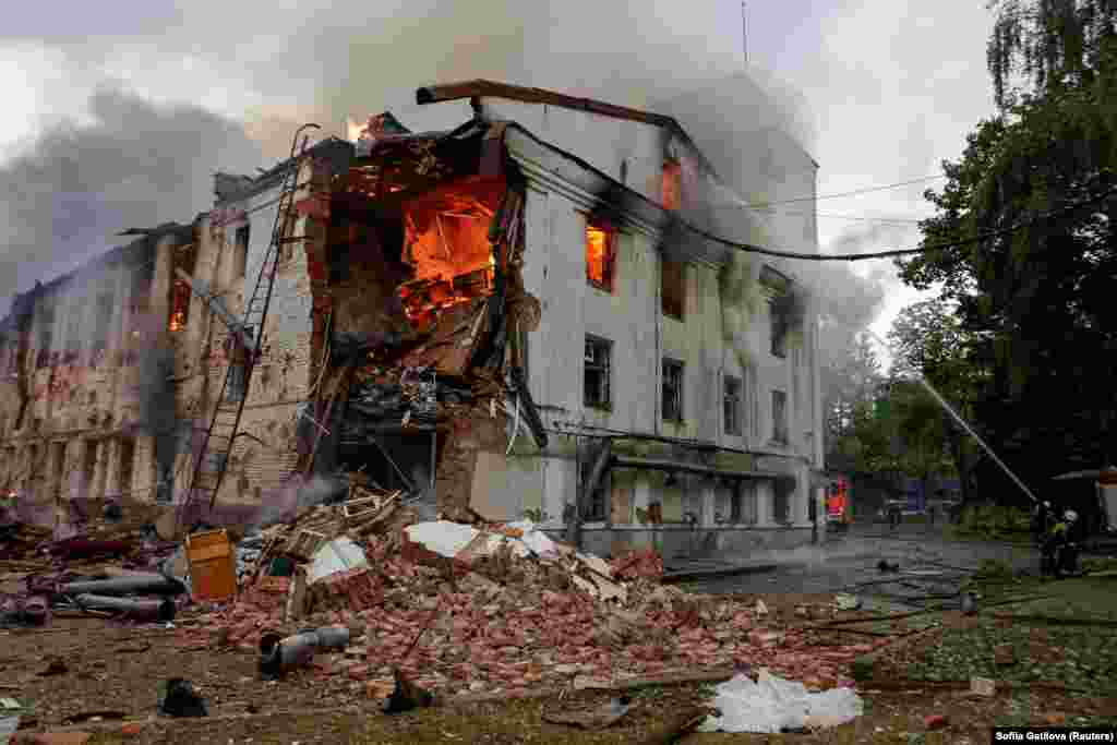 Firefighters work at the site of a building hit by a Russian drone strike in Kharkiv.