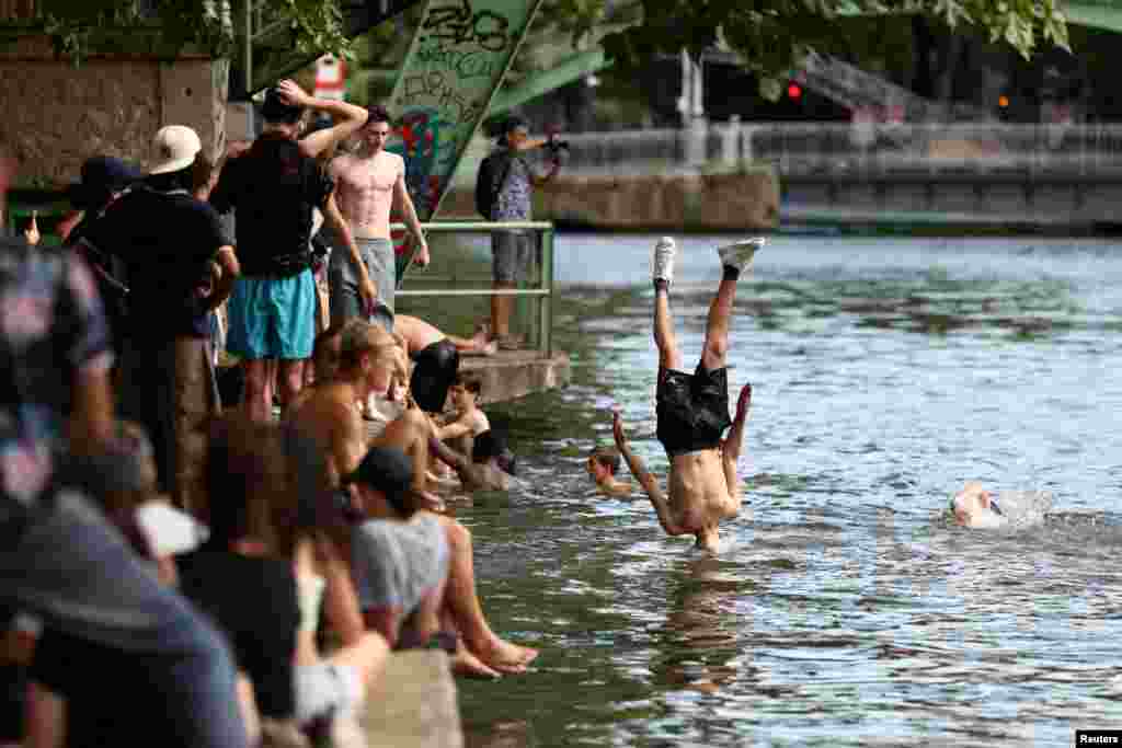 Mladi skaču u kanal Saint-Martin za vrijeme sunčanog dana u Parizu, Francuska, 2. jula.