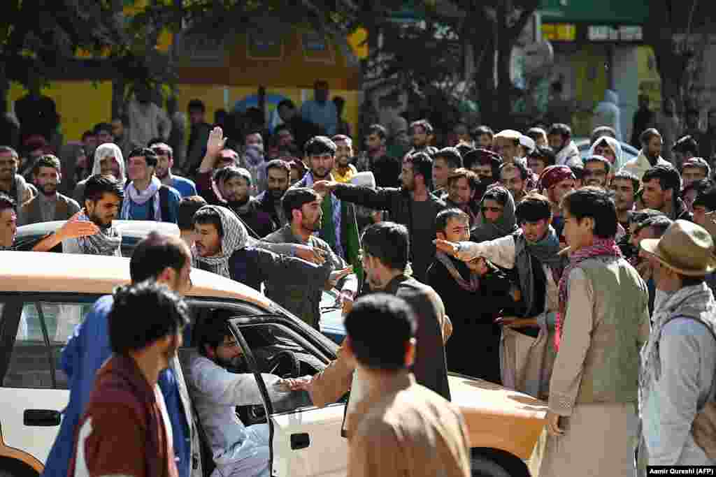 Crowds gather outside a closed branch of a Kabul bank on August 28. Since the Taliban seized power in Kabul, many government buildings, banks, schools, and universities have remained closed. As prices rise, cash is reportedly becoming harder to acquire. &nbsp;