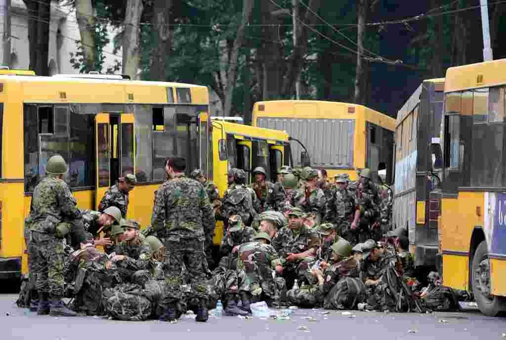 Caption: epa01436235 Georgian called-up reservists sit at the central square of Gori, having rest on their way to Tskhinvali region, Georgia 09 August 2008. Russian and Georgian armed forces were locked in combat on Friday over control of the Caucasus region South Ossetia, with hundreds of civilians reported killed or injured.