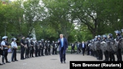 Președintele american Donald Trump și anturajul său salută poliția care tocmai „curățase” un parc de demonstranți pașnici, pentru a permite deplasarea președintelui la biserica din apropiere, 1 iunie 2020.