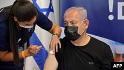 Израилдин мурдагы премьер-министри Беньямин Нетаньяху коронавируска каршы вакцинанын үчүнчү дозасын алып жатат. 30-июль, 2021-жыл. Тель-Авив. 