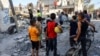 Fëmijët duke shikuar ekipet e kërkimit për ndonjë viktimë që mund të ketë mbetur nën rrënoja, pas sulmeve ajrore izraelite në jug të Gazës.
