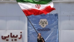An Iranian woman waves a national flag at Valiasr Square in Tehran on June 15. 