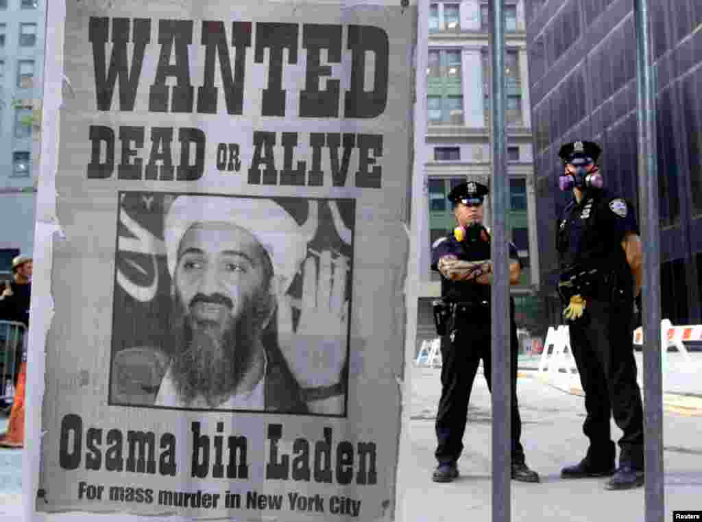 Deși, inițial, Osama bin Laden a negat orice implicare în atentatele din 11 septembrie, în 2004 a revendicat în mod oficial responsabilitatea atacurilor. Al-Qaeda și bin Laden au motivat actul terorist prin dezacordul față de sprijinul SUA pentru Israel, prezența trupelor americane în Arabia Saudită și sancțiunile împotriva Irakului.&nbsp; În imagine, polițiști din New York stau lângă un afiș tipărit pe pagina unui ziar din New York, cu portretul lui Osama bin Laden. &nbsp;