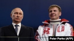 Russian President Vladimir Putin (left) and bobsleigh pilot Aleksandr Zubkov at the closing ceremony of the Sochi Olympics in 2014. 