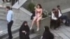 This image grab from a UGC video posted on November 2, 2024, and widely shared on social media shows a female student in her underwear outside Tehran's Islamic Azad University.