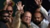 Former Pakistani Prime Minister Nawaz Sharif (center) waves to supporters during a rally on his "caravan of democracy" protest drive. 