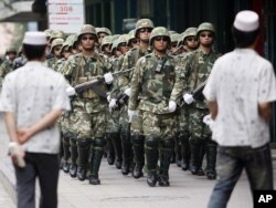 Отряд китайской полиции шагает по Урумчи. 19 июля 2009 года.
