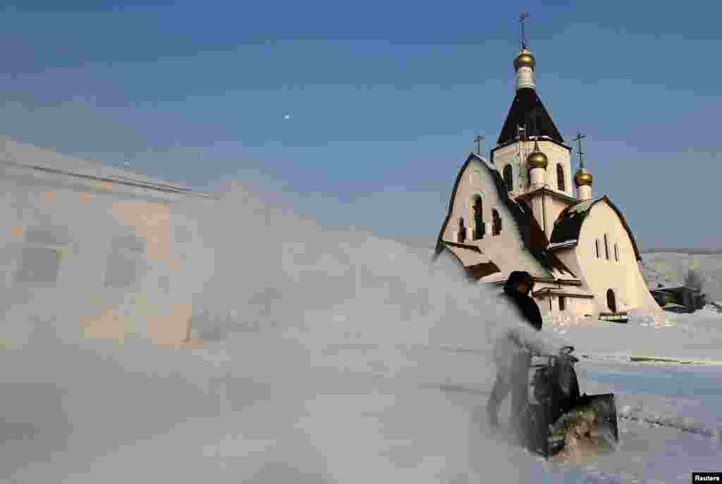 A monk removes snow from a compound at the Uspensky monastery during preparations for an Orthodox Christmas night service near the Siberian city of Krasnoyarsk, Russia. (Reuters/Ilya Naymushin)