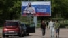 People walk near a banner in support of the Russian Army in Vyborg, Russia.