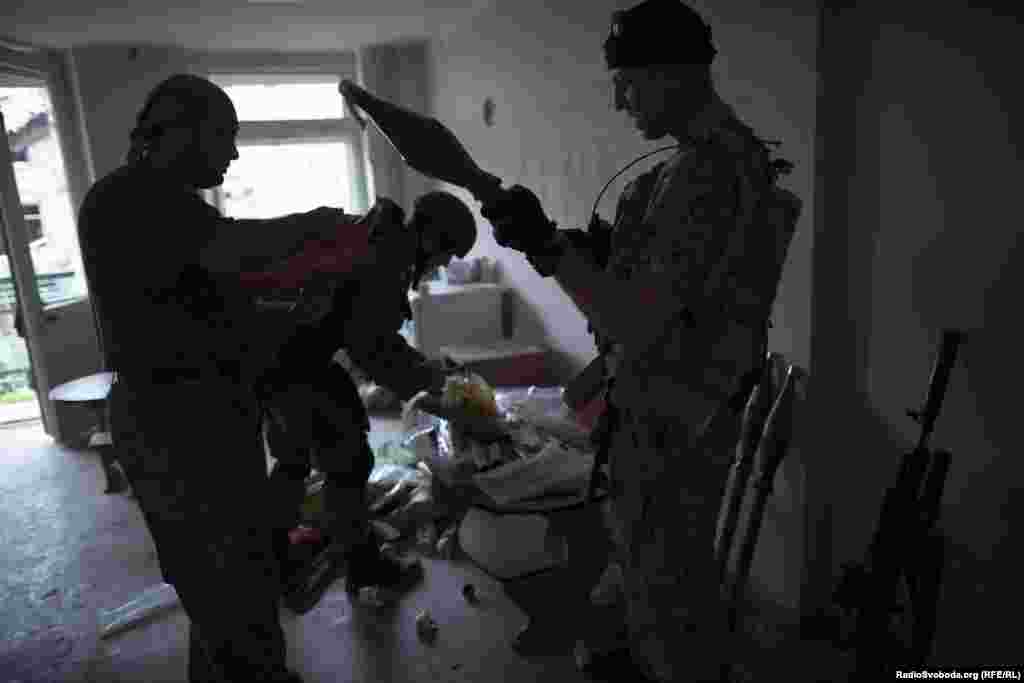 Following an attack by pro-Russian separatists, soldiers pick up their weapons to return to the front lines.