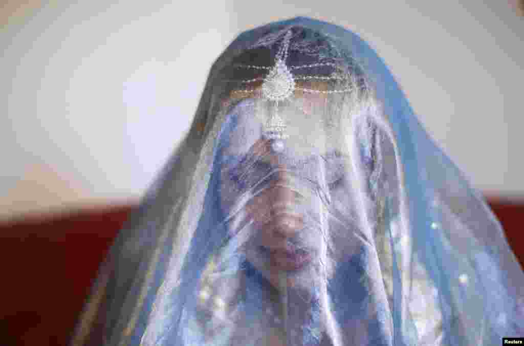 Sundas wears a Pakistani wedding veil ahead of her traditional Islamic wedding blessing. Sundas started wearing a head scarf at age 18 despite her parents' opposition. Sundas says: "I was determined to wear it nonetheless as I had a conviction in my heart that I wanted to please God instead of people. I don't have such a strict interpretation of covering now; instead I focus more on modesty and moderate covering."
