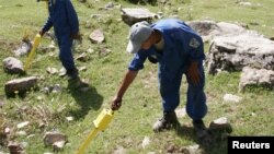 FILE: Sappers use detectors to search for undetonated ammunition in Tajikistan.