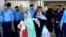 Žena sa bebom prolazi pored policajaca dok napušta odjeljenje nakon smrtonosnog požara u bolnici Pakistanskog instituta medicinskih nauka u Islamabadu, Pakistan, 26. augusta 2026.