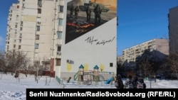 Çagalar ýaşaýyş jaýyň diwarynda söweş meýdanyndaky harbylary şekillendirýän suratyň öňünden geçýärler. Kiýew, 2026-njy ýylyň fewraly.