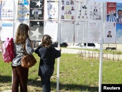Тунисцы изучают предвыборные постеры. Тунис, 19 октября 2011 года.