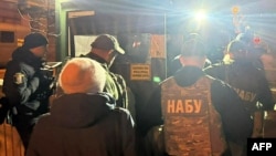 Officers from Ukraine's National Anti-Corruption Bureau pass through a checkpoint in the government district in Kyiv as they conduct a raid on the office of Andriy Yermak early on November 28. 