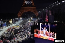 „Omul albastru” este văzut pe un ecran în timp ce delegațiile țărilor sosesc la Trocadero în timpul ceremoniei de deschidere a Jocurilor Olimpice Paris 2024, 26 iulie 2024.