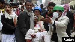 Opposition protesters carry an injured fellow protester in Sanaa on March 18.