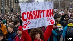  Жена държи афиш с надпис 