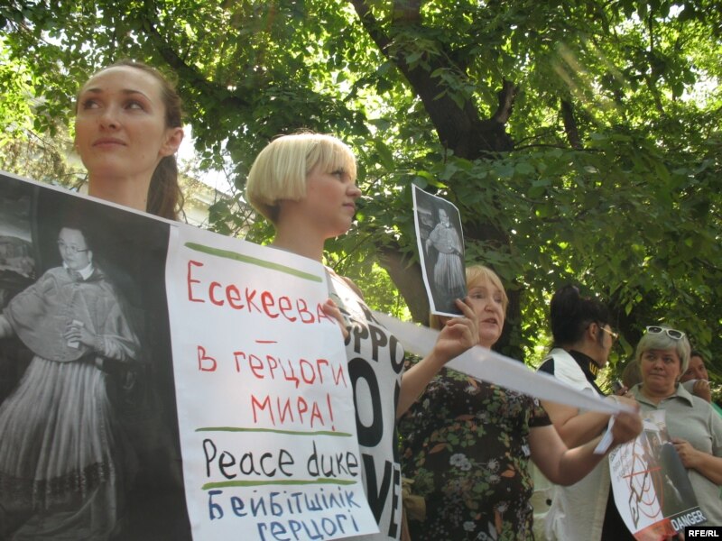 Участница акции протеста в защиту СМИ держит плакат с изображением председателя Агентства по информатизации и связи, разработавшего закон об Интернете, Куанышбека Есекеева в одежде герцога. Алматы, 24 июня 2009 года
