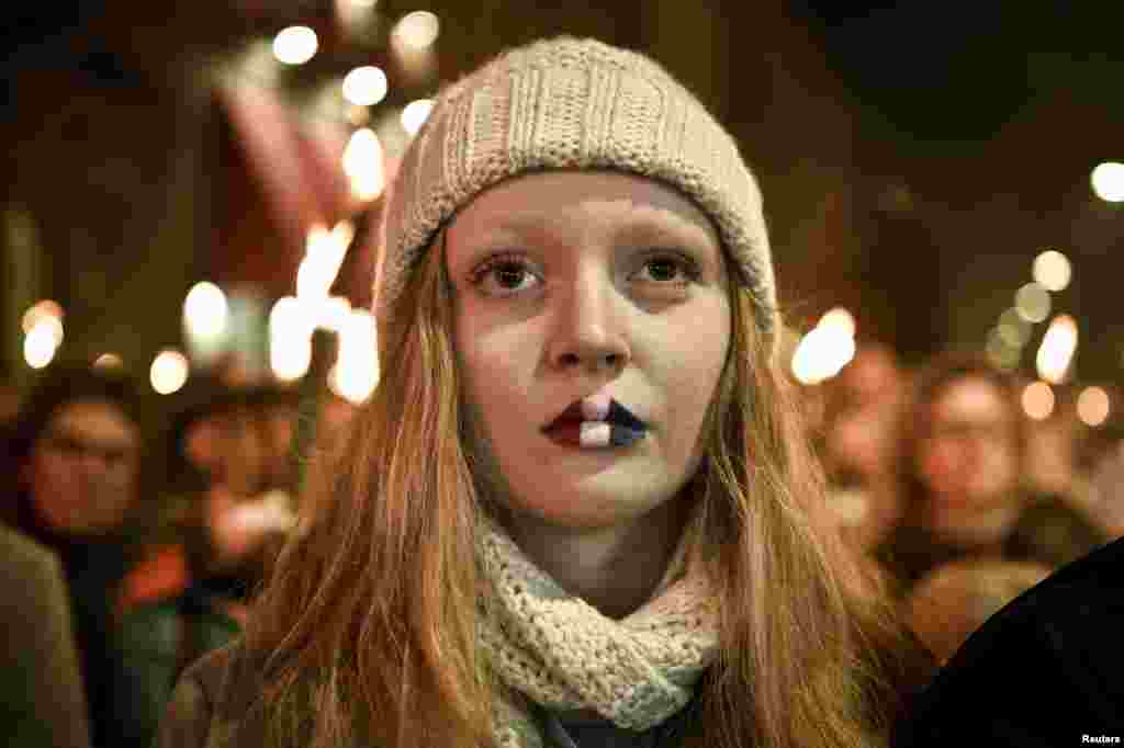 A girl with her lips painted in the French colours attends a commemoration event in front of the French Embassy in Copenhagen in memory of victims of the Paris attacks on November 13. (Reuters/​Nils Meilvang)