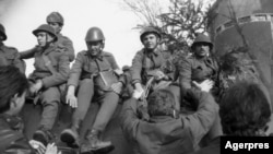 Militari români pe 22 Decembrie 1989, primind flori de la demonstranți după fuga lui Nicolae Ceaușescu cu elicopterul. În noaptea de 21/22 Decembrie, trupe ale Armatei Române și ale Securității trăseseră din plin în manifestanții din jurul Baricadei de la Inter.