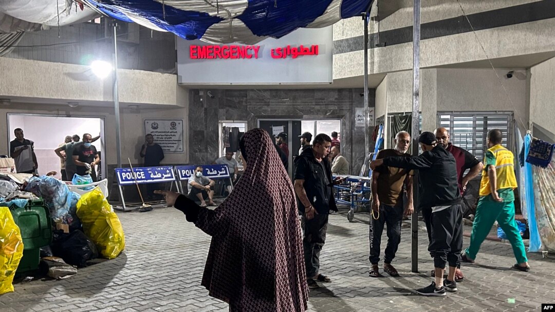 Oamenii stau în fața secției de urgență a spitalului Al-Shifa din orașul Gaza, pe 10 noiembrie 2023, pe fondul luptelor în curs dintre Israel și mișcarea palestiniană Hamas.