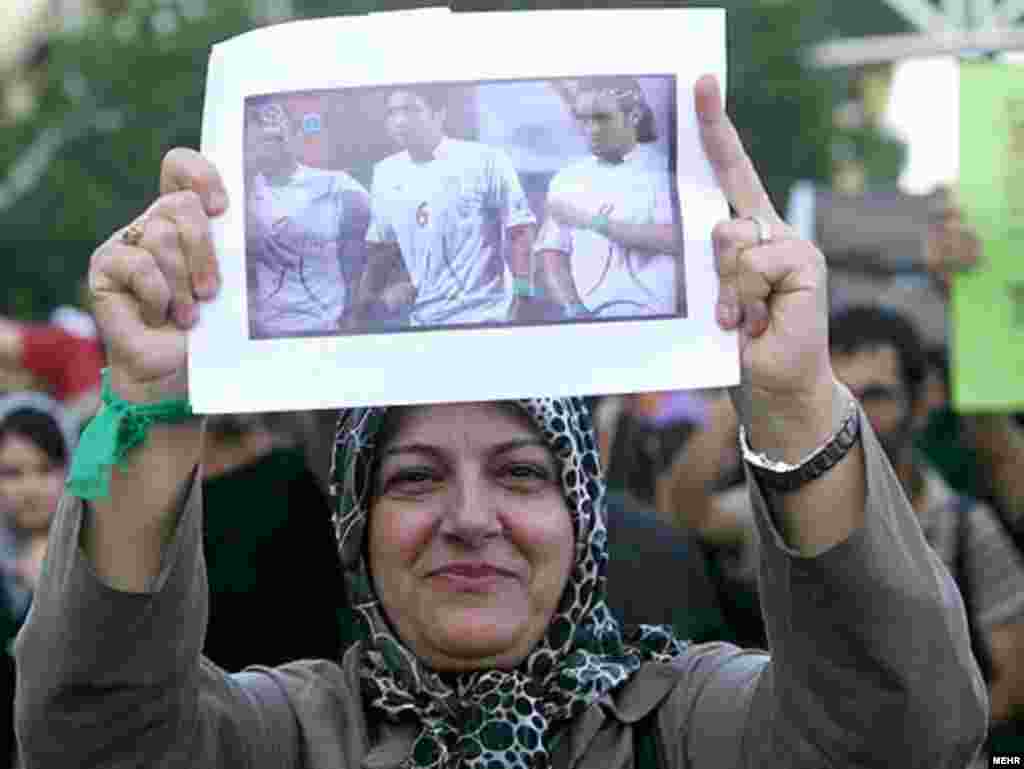 Fotografie a echipei de fotbal iraniene arborată de o demonstrantă pro-Musavi.