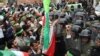 Iran -- Riot police stand guard as demonstrators shout slogans and wave their national flag during a protest outside the Italian embassy in Tehran, 09Feb2010