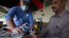 A volunteer helps a passenger arriving at a railway station to wash hands as a measure to help prevent the spread of the coronavirus in the northwestern city of Peshawar on March 17.