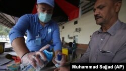 پېښور کې یو خدای خدمتګار رېل ګاډي ته تر ختو وړاندې د یوه کس لاس په سنېټیایزو ورپاکوي. 