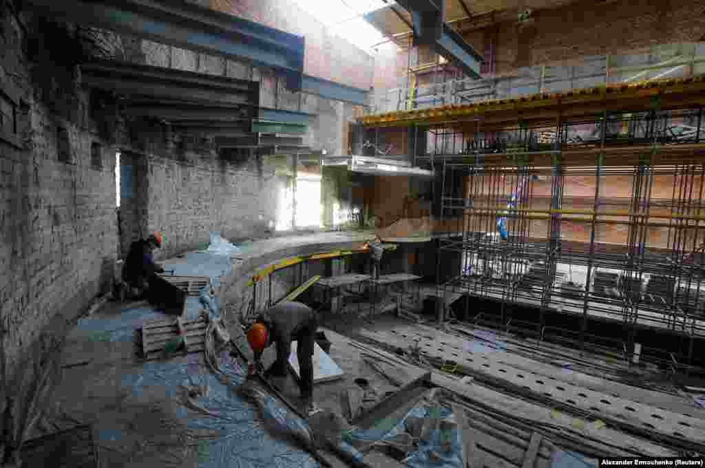 Workers rebuilding the theater in January 2025. The reconstruction is widely viewed by locals as a propaganda showpiece in a city where large swathes of infrastructure remain in ruins. 