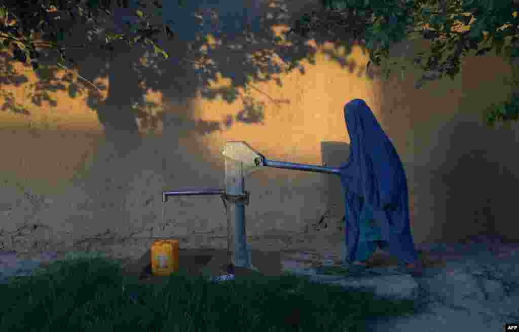 An Afghan woman collects water from a hand pump in Mazar-e Sharif in Ghazni Province. (AFP/Farshad Usyan)