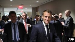 French President Emmanuel Macron, flanked by his advisors and security agents walk from one meeting to another at the United Nations headquarter on September 23, 2019, in New York