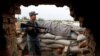 An Afghan policeman keeps watch at the check post on the outskirts of Kabul on July 13.