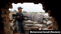 An Afghan policeman keeps watch at the check post on the outskirts of Kabul on July 13.