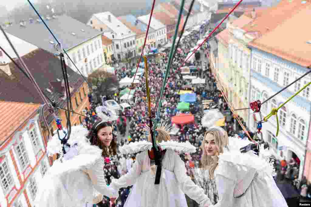 Femei îmbrăcate în costume de îngeri participă la târgul de Crăciun din orașul Ustek, Republica Cehă, pe 13 decembrie 2025.