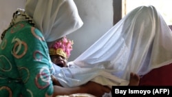 Девочка после традиционной процедуры обрезания в Индонезии