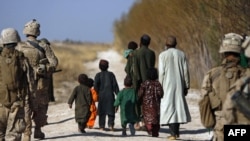 U.S. Marines escort farmers fleeing their land as Marines battle Taliban in Trikh Nawar, near Marjah.