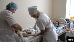 врачи с подростком, раненным во время обстрела школы под Донецком, 6 ноября 2014 года. 