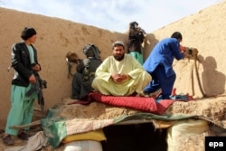 Afghan Local Police (ALP) take positions during an operation against Taliban militants in Sangin on January 31