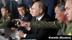 Russian President Vladimir Putin (center) and Kyrgyz counterpart Sooronbai Jeenbekov observe the military exercises near Orenburg on September 20.