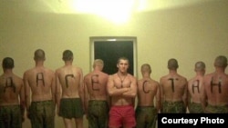 Hazing is a big problem in the Russian army. In this file photo, a man stands in front of other soldiers with letters that make out the word "Dagestan" on their backs.
